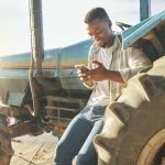 Young farmer using his mobile phone.